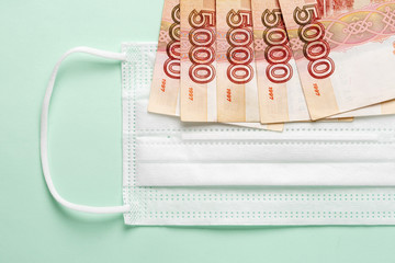 Medical mask with Russian money lying on it. The concept of increasing prices for medical masks in connection with the fear of the spread of the coronavirus epidemic in Russia