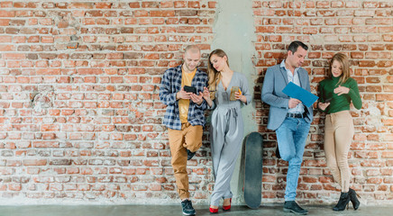 Team of people in startup company standing on brick wall - obrazy, fototapety, plakaty