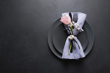 Elegance table setting spring pink tulip on black. Easter dinner. Top view.