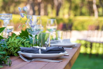 Preparing for an open-air party. Decorated with fresh flowers served tables. Table number. Decoration Details