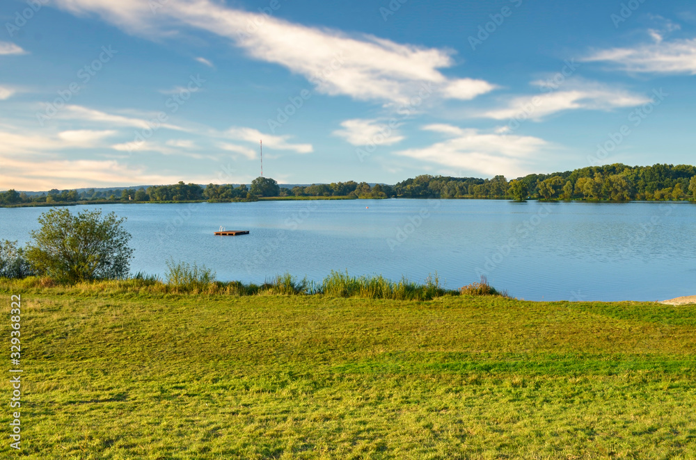 Wall mural view to the gartower lake in lower saxony, germany, under a blue sky.