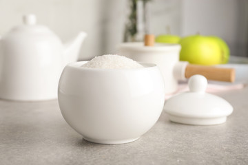 Fototapeta na wymiar Ceramic bowl with white sugar on grey table