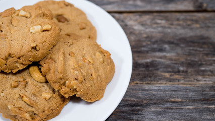 Cashew cookies in a half plate, placed on a wooden table