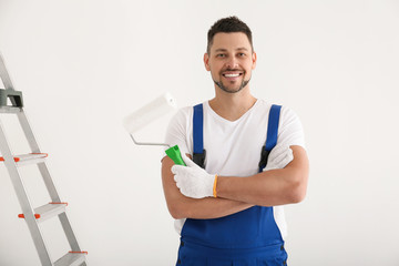 Man holding roller in empty room. Interior renovation
