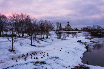 A view to abandoned church in small town Suzdal in Golden Ring, Russia, from the bridge. Ducks are resting near the river