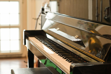 Cropped shot of Classical piano in a room with natural light through beautiful window.