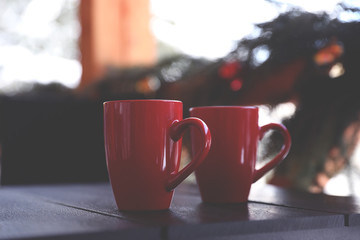 Red cups on wooden table outdoors. Winter vacation