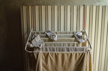 Little clotheshorse hanging on the radiator with towels, socks and a t-shirt (Pesaro, Italy, Europe)