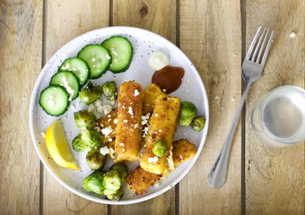 Delicious fish sticks and Brussel sprouts for dinner ona wood tray