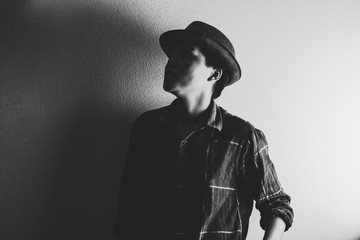 Asian man in Scott shirt and wearing a vintage cap looking on gray background. the darkness of black and white tone