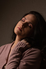 Obraz premium Sensual brunette girl with long curly hair in the shadow