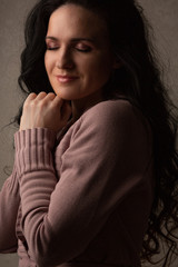 Fototapeta premium Pretty brunette girl with long curly hair in the shadow