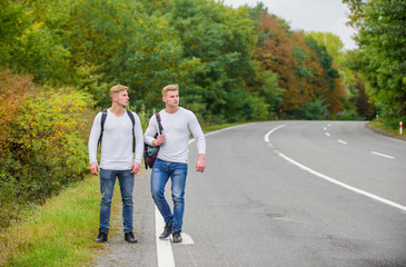 Start conversing. road trip. wanderlust. Hiking with friends is cool. gone to find themselves. Travel and hitch-hiking. twins walking along road. hitch hiking on empty road. travelling by hitchhiking