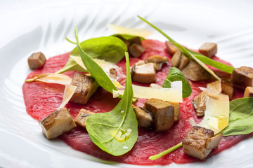 Carpaccio di manzo con funghi porcini, grana padano e rucola