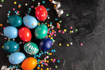 Colorful easter eggs on a dark background. Background with easter eggs. Top view. Copy space