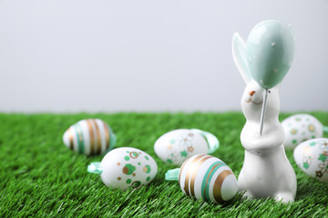 Fototapeta na wymiar Easter bunny figure and eggs on green grass. Space for text