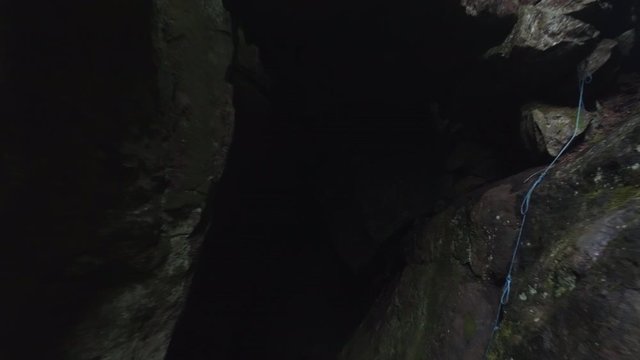 Flying into cave in ravine. Drone shot flying in ravine and into dark cave, nature background in 4K resolution