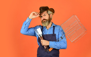 Spring season. Cooking meat. Roasting meat. Picnic and barbecue. Steak and barbecue. Barbecue menu. Bearded hipster wear hat and apron for barbecue. Grilling food. American picnic. Family tradition