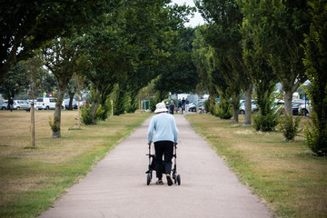 Naklejka premium an elderly lady walking the a park using a walking aid or mobility aid