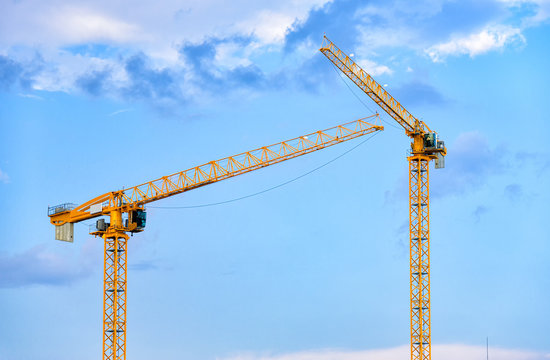 Construction cranes over blue sky