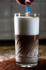 Making latte pouring espresso into whipped milk