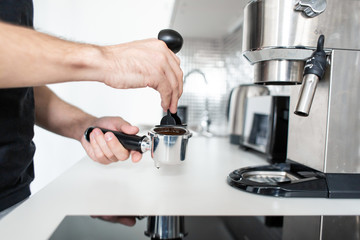 Guy prepare delicious aromatic coffee in a coffee machine. A simple way to make coffee