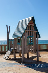 A child's climbing frame and tree house in a playground