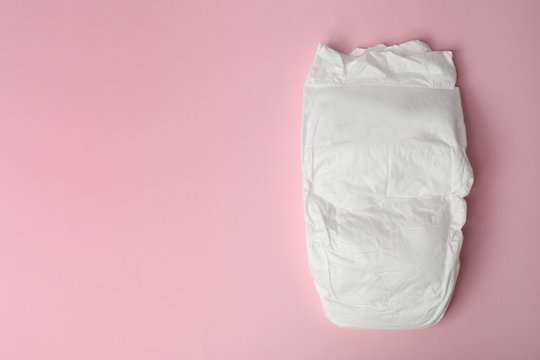 Baby diaper on pink background, top view. Space for text