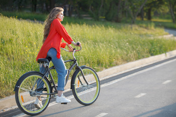Obraz premium Woman rides a bicycle in a city park.