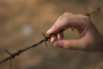 hand with barbed wire