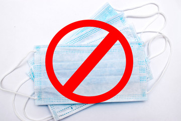 Flat lay protective medical face masks and red sign prohibited on the white background.Соncept...