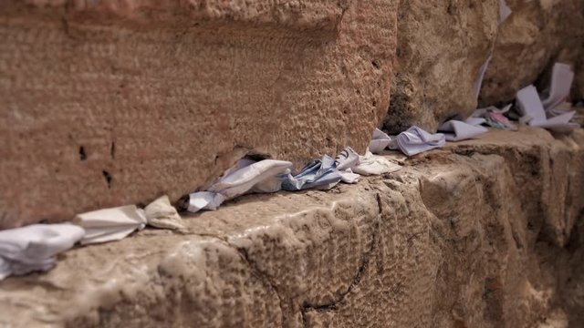 Footage of notes in the cracks of Western Wall (Kotel) Jerusalem. Israel. Dynamic video. Selective focus
