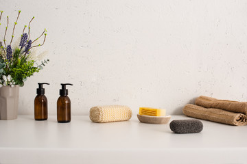 Flowerpot, towels, hygiene and cosmetic products in bathroom, zero waste concept