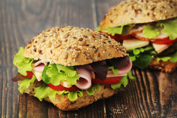 Two sandwiches with whole grain bread, ham and vegetables	
