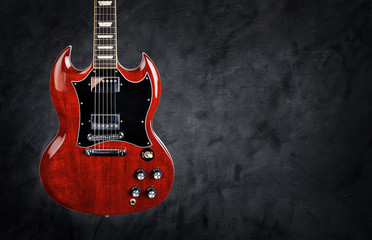 Red electric guitar on a dark grunge background