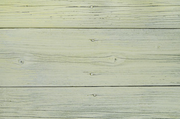 Old boards covered with faded yellow paint, texture