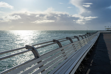 white wooden benches lining a british seaside pier