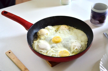 Traditional fried eggs on frying pan for delicious healthy easy breakfast on a white table. Top view. - Image