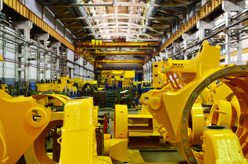 Production process of heavy mining trucks at the factory. Dump truck on the Industrial conveyor in the workshop of an automobile plant. Manufacturer of haulage and earthmoving equipment, haul trucks