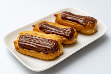plate cakes chocolate icing on white background