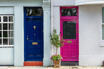 Fototapeta na wymiar Two colourful front doors side by side one blue and one pink