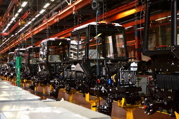 Tractor Manufacture works. Assembly line inside the agricultural machinery factory. Installation of...