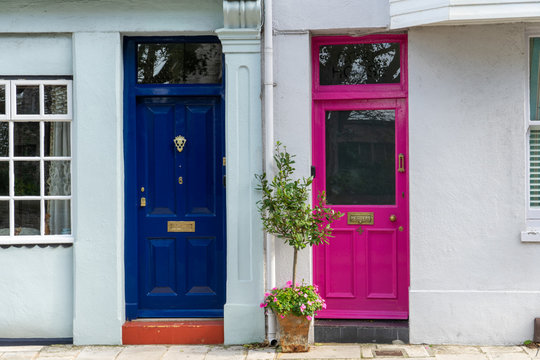 Two colourful front doors side by side one blue and one pink