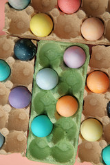 Colored, colored eggs lie on a pink background, Easter holiday.