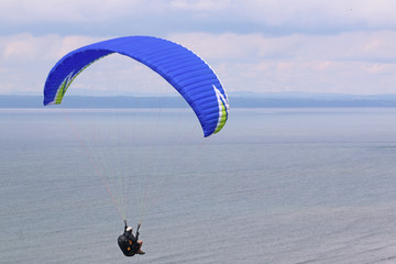 Paraglider flying above the sea