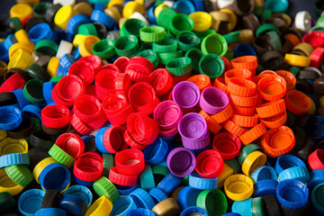 Plastic bottle caps background. Cap material is recyclable.Remove lids from plastic bottles before recycling them. Recycling collection and processing plastic bottle caps