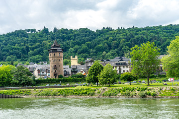 Fototapeta na wymiar Germany, Rhine Romantic Cruise, a castle on top of a lake surrounded by green grass and trees