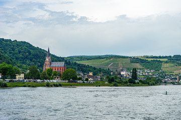 Obraz premium Germany, Rhine Romantic Cruise, a large body of water with a mountain in the background