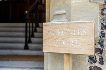 A wooden sign showing the words Coroners office