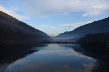 Landscape with lake and the town covered with mist